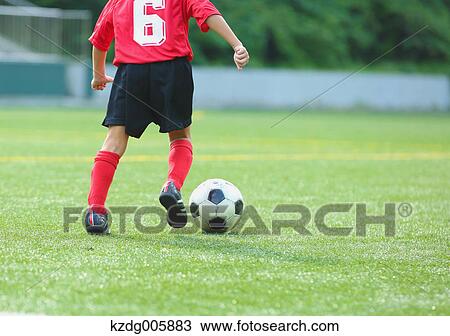Stock Image - Japanese kid playing soccer. Fotosearch
