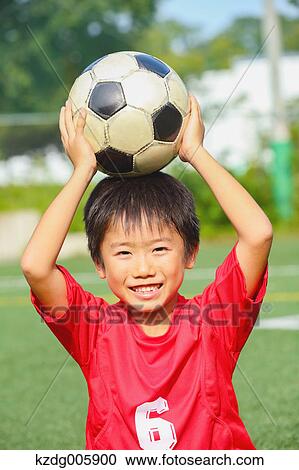 Stock Image - Japanese kid playing soccer. Fotosearch