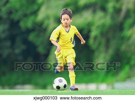 Stock Image - Japanese kid playing soccer. Fotosearch