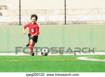 Stock Image - Japanese kid playing soccer. Fotosearch