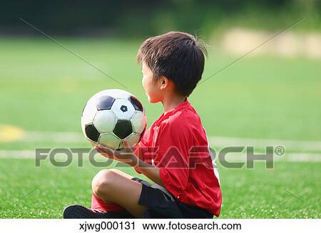 Stock Image - Japanese kid playing soccer. Fotosearch