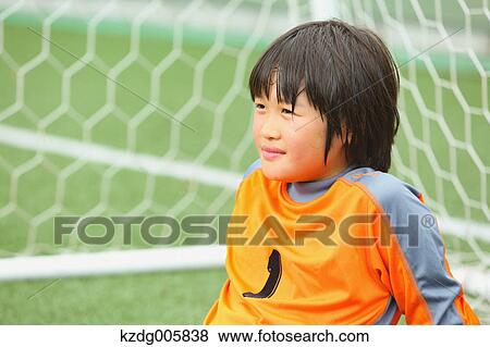 Stock Photo - Japanese kid playing soccer. Fotosearch