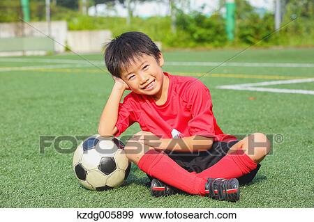 Stock Photo - Japanese kid playing soccer. Fotosearch