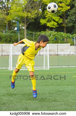 Stock Photo - Japanese kid playing soccer. Fotosearch