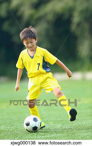 Stock Photo - Japanese kid playing soccer. Fotosearch