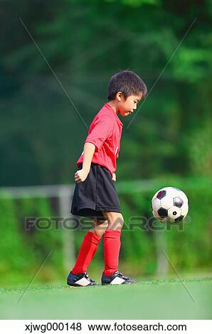 Stock Photo - Japanese kid playing soccer. Fotosearch