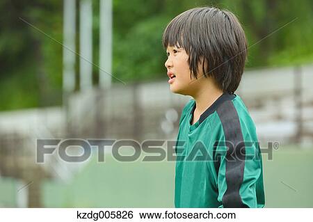 Stock Photograph - Japanese kid playing soccer. Fotosearch