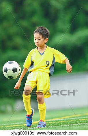 Stock Photography - Japanese kid playing soccer. Fotosearch