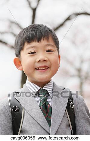 Stock Photograph - Japanese kid with cherry blossoms in a city park. Fotosearch