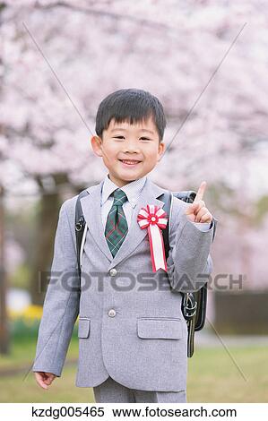 Stock Photography - Japanese kid with cherry blossoms in a city park. Fotosearch