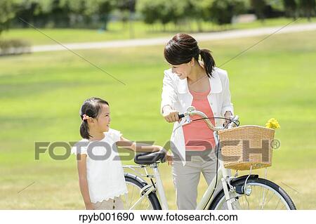 Stock Image - Japanese kid with mother at the park. Fotosearch