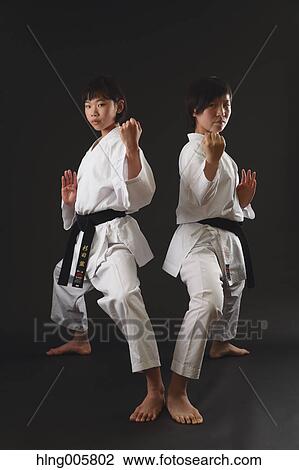 Stock Image - Japanese kids in karate uniform on black background. Fotosearch