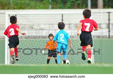 Stock Image - Japanese kids playing soccer. Fotosearch