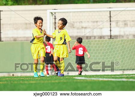 Stock Image - Japanese kids playing soccer. Fotosearch