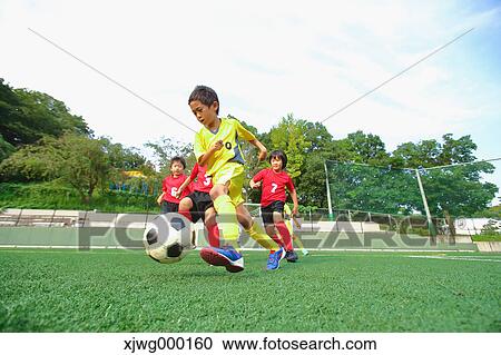 Stock Image - Japanese kids playing soccer. Fotosearch