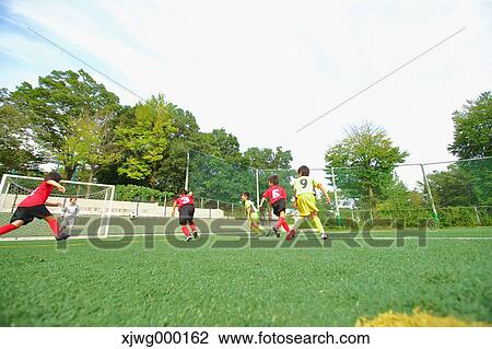 Stock Image - Japanese kids playing soccer. Fotosearch