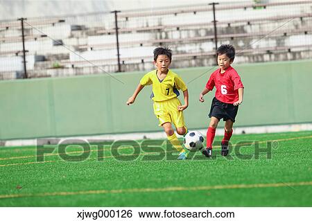 Stock Photograph - Japanese kids playing soccer. Fotosearch