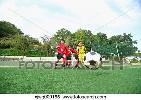 Stock Photography - Japanese kids playing soccer. Fotosearch