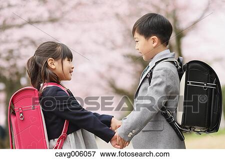 Stock Photo - Japanese kids with cherry blossoms in a city park. Fotosearch