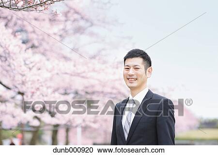 Japanese man with cherry blossoms in a city park View Large Photo Image Stock Image - Japanese man with cherry blossoms in a city park. Fotosearch