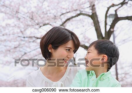 Japanese mother and son with cherry blossoms in a city park View Large Photo Image Stock Image - Japanese mother and son with cherry blossoms in a city park. Fotosearch