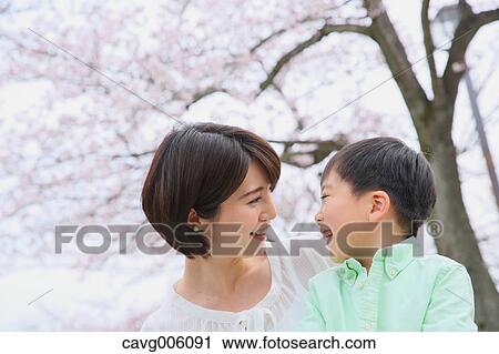 Japanese mother and son with cherry blossoms in a city park View Large Photo Image Stock Image - Japanese mother and son with cherry blossoms in a city park. Fotosearch