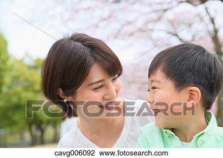 Japanese mother and son with cherry blossoms in a city park View Large Photo Image Stock Image - Japanese mother and son with cherry blossoms in a city park. Fotosearch