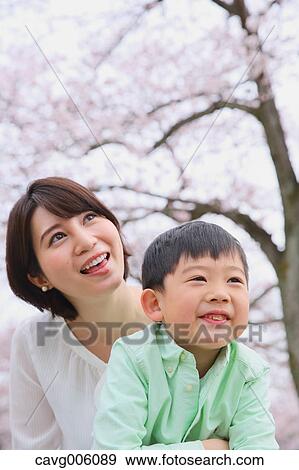 Japanese mother and son with cherry blossoms in a city park View Large Photo Image Stock Photo - Japanese mother and son with cherry blossoms in a city park. Fotosearch
