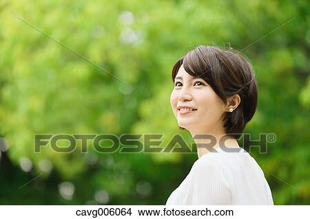 Picture - Japanese woman in a city park. Fotosearch
