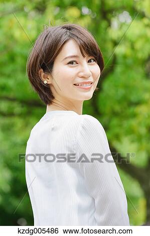 Stock Photograph - Japanese woman in a city park. Fotosearch