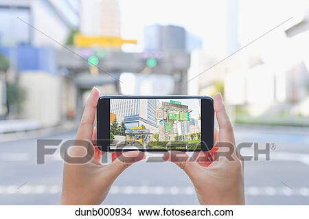 Japanese woman using augumented reality app on smartphone downtown Tokyo, Japan View Large Photo Image Picture - Japanese woman using augumented reality app on smartphone downtown Tokyo, Japan. Fotosearch