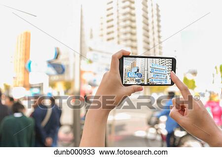 Japanese woman using augumented reality app on smartphone downtown Tokyo, Japan View Large Photo Image Stock Image - Japanese woman using augumented reality app on smartphone downtown Tokyo, Japan. Fotosearch