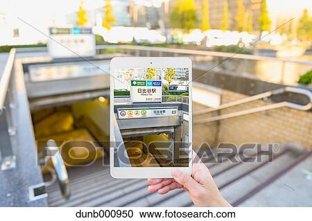 Japanese woman using augumented reality app on tablet downtown Tokyo, Japan View Large Photo Image Stock Image - Japanese woman using augumented reality app on tablet downtown Tokyo, Japan. Fotosearch