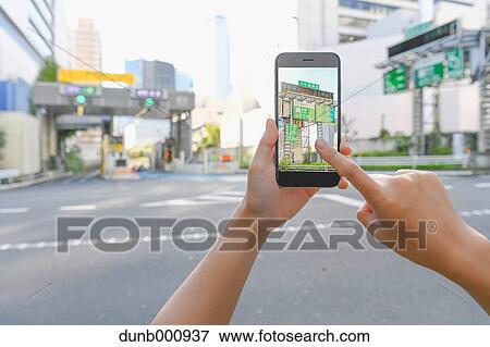 Japanese woman using augumented reality app on smartphone downtown Tokyo, Japan View Large Photo Image Stock Photo - Japanese woman using augumented reality app on smartphone downtown Tokyo, Japan. Fotosearch
