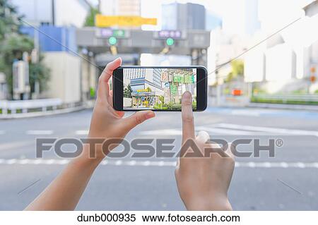 Japanese woman using augumented reality app on smartphone downtown Tokyo, Japan View Large Photo Image Stock Photography - Japanese woman using augumented reality app on smartphone downtown Tokyo, Japan. Fotosearch