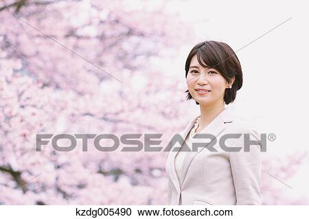 Japanese woman with cherry blossoms in a city park View Large Photo Image Stock Image - Japanese woman with cherry blossoms in a city park. Fotosearch