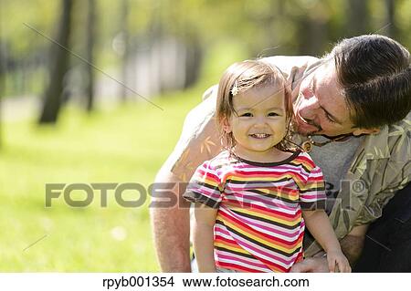 Kid and dad playing in a city park View Large Photo Image Picture - Kid and dad playing in a city park. Fotosearch