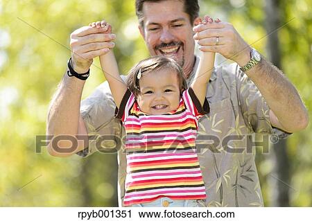 Kid and dad playing in a city park View Large Photo Image Stock Image - Kid and dad playing in a city park. Fotosearch