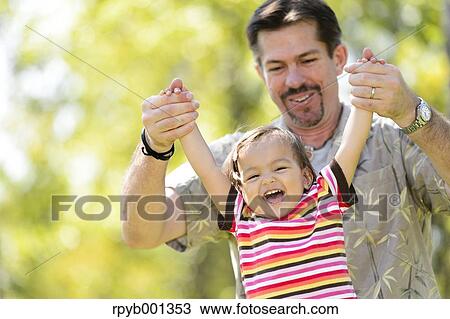 Kid and dad playing in a city park View Large Photo Image Stock Image - Kid and dad playing in a city park. Fotosearch