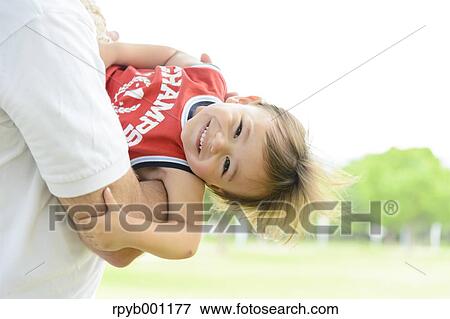 Kid and dad playing in a city park View Large Photo Image Stock Photo - Kid and dad playing in a city park. Fotosearch