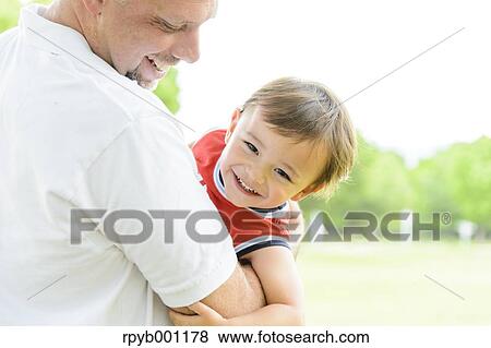 Kid and dad playing in a city park View Large Photo Image Stock Photo - Kid and dad playing in a city park. Fotosearch