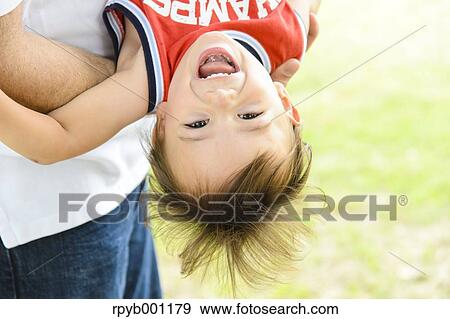 Kid and dad playing in a city park View Large Photo Image Stock Photo - Kid and dad playing in a city park. Fotosearch