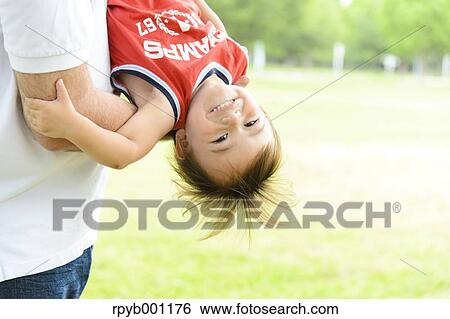 Kid and dad playing in a city park View Large Photo Image Stock Photograph - Kid and dad playing in a city park. Fotosearch