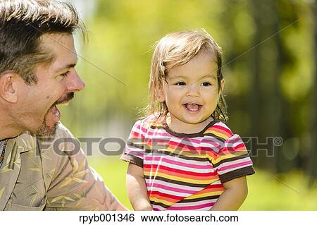 Kid and dad playing in a city park View Large Photo Image Stock Photograph - Kid and dad playing in a city park. Fotosearch