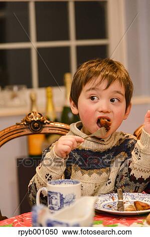 Kid eating in the house at Christmas View Large Photo Image Stock Image - Kid eating in the house at Christmas. Fotosearch