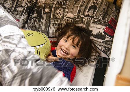 Stock Photograph - Kid playing in bed. Fotosearch