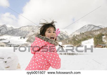 Kid playing in the snow View Large Photo Image Stock Photo - Kid playing in the snow. Fotosearch