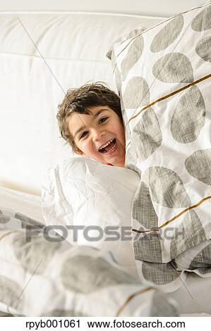 Kid playing on bed in a pijama View Large Photo Image Stock Image - Kid playing on bed in a pijama. Fotosearch