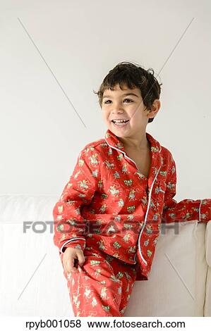 Stock Photo - Kid playing on bed in a pijama. Fotosearch