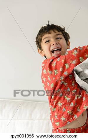 Kid playing on bed in a pijama View Large Photo Image Stock Photograph - Kid playing on bed in a pijama. Fotosearch